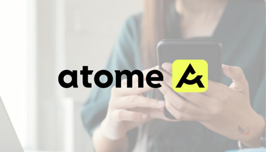 Person using a smartphone with the Atome logo displayed